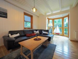 ein Wohnzimmer mit einer schwarzen Couch und einem Tisch in der Unterkunft Ferienhaus Marie in Binz