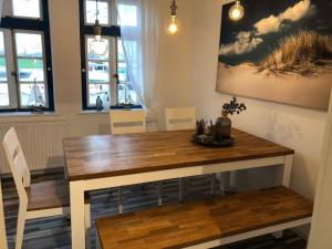 a dining room with a wooden table and chairs at Wohnung 4 in Fedderwardersiel