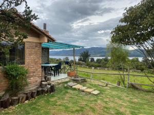 Cette maison dispose d'une terrasse avec une table dans la cour. dans l'établissement Rancho New Life Guatavita, à Guatavita