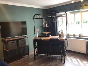 a room with a table with chairs and a television at Wohnung 5 in Fedderwardersiel