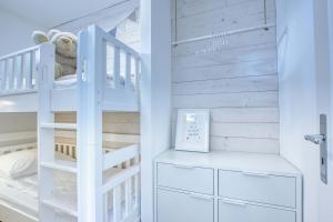 a baby room with a white bunk bed and stairs at Landhaus am Ufer - Wohnung 3 in Heiligenhafen