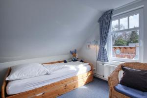 1 dormitorio con cama de madera y ventana en Landhaus am Ufer - Wohnung 4, en Heiligenhafen
