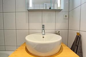 a bathroom with a white sink on a wooden counter at Haus am Binnensee in Heiligenhafen