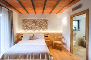 LlimianaにあるMasia Mateu de l'Agustíの木製の天井が特徴のベッドルーム1室(ベッド1台付)