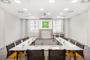 a room with tables and chairs and a screen with a bus stop at Ibis Styles Budapest City in Budapest