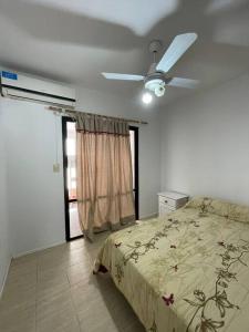 - une chambre avec un lit et un ventilateur de plafond dans l'établissement Departamento céntrico con garaje, cocina, WIFI, à Concordia