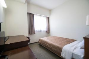 a hotel room with a bed and a window at Minami Fukuoka Green Hotel in Fukuoka
