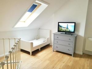 een slaapkamer met een bed en een tv op een dressoir bij Apartmentvermittlung Mehr als Meer - Objekt 74 in Niendorf