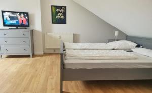 een slaapkamer met een bed en een dressoir met een tv bij Apartmentvermittlung Mehr als Meer - Objekt 74 in Niendorf