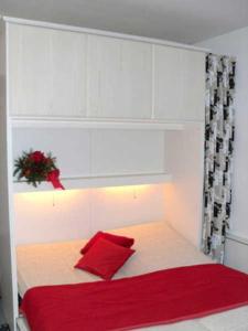 ein Schlafzimmer mit einem roten Kissen auf dem Bett in der Unterkunft Apartmentvermittlung Mehr als Meer - Objekt 4 in Timmendorfer Strand