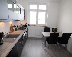 eine Küche mit einem Tisch und Stühlen sowie einem Fenster in der Unterkunft Appartementvermittlung Mehr als Meer Objekt 50 in Timmendorfer Strand