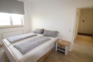 ein Schlafzimmer mit einem großen Bett und einem Tisch in der Unterkunft Appartementvermittlung Mehr als Meer Objekt 50 in Timmendorfer Strand