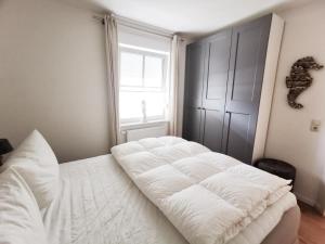- un lit blanc dans une chambre avec fenêtre dans l'établissement Apartmentvermittlung Mehr als Meer - Objekt 26, à Timmendorfer Strand