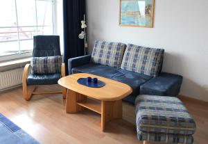 a living room with a couch and a coffee table at Apartmentvermittlung Mehr als Meer - Objekt 54 in Niendorf