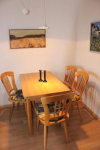 a wooden table with four chairs in a room at Apartmentvermittlung Mehr als Meer - Objekt 54 in Niendorf