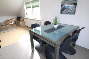 a dining room with a glass table and chairs at Apartmentvermittlung Mehr als Meer - Objekt 8 in Niendorf