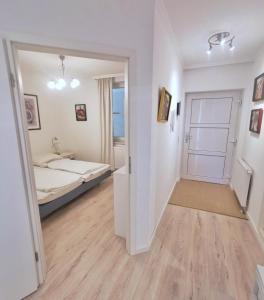 a white room with a bed and a door at Apartmentvermittlung Mehr als Meer - Objekt 77 in Niendorf