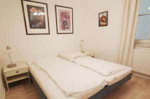 a bed in a room with two tables and two pictures on the wall at Apartmentvermittlung Mehr als Meer - Objekt 77 in Niendorf