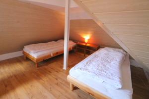 a attic room with two beds and a lamp at Apartmentvermittlung Mehr als Meer - Objekt 41 in Niendorf