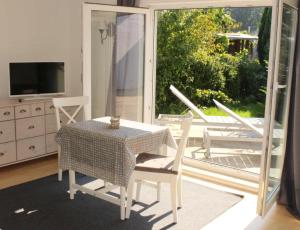 a dining room with a table and chairs and a balcony at Apartmentvermittlung Mehr als Meer - Objekt 1 in Timmendorfer Strand