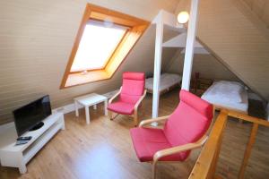 a room with two pink chairs and a bunk bed at Apartmentvermittlung Mehr als Meer - Objekt 41 in Niendorf