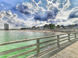 a beach with a wooden boardwalk and a fence at Apartmentvermittlung Mehr als Meer - Objekt 23 in Niendorf