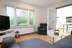 sala de estar con sofá y TV de pantalla plana en Apartmentvermittlung Mehr als Meer - Objekt 56, en Scharbeutz