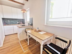 uma cozinha com mesa e cadeiras num quarto em Objekt 38 em Niendorf