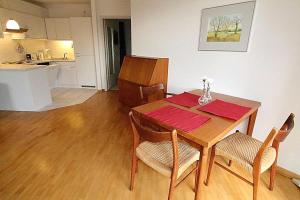 une salle à manger avec une table et des chaises ainsi qu'une cuisine dans l'établissement Apartmentvermittlung Mehr als Meer - Objekt 16, à Niendorf