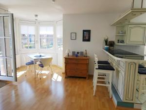 ein Wohnzimmer mit einer Küche und einem Tisch mit Stühlen in der Unterkunft Apartmentvermittlung Mehr als Meer - Objekt 10 in Niendorf