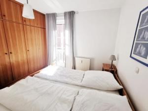 1 Schlafzimmer mit 2 Betten und einem großen Fenster in der Unterkunft Apartmentvermittlung Mehr als Meer - Objekt 10 in Niendorf