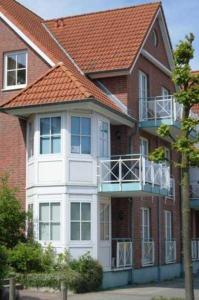 ein großes Backsteingebäude mit orangefarbenem Dach in der Unterkunft Apartmentvermittlung Mehr als Meer - Objekt 10 in Niendorf