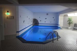 a large swimming pool with blue water in a room at Apartmentvermittlung Mehr als Meer - Objekt 70 in Niendorf
