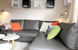 a living room with a gray couch with colorful pillows at Apartmentvermittlung Mehr als Meer - Objekt 48 in Niendorf