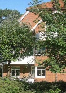 a brick building with trees in front of it at Apartmentvermittlung Mehr als Meer - Objekt 48 in Niendorf