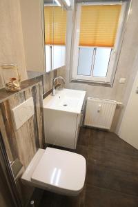 a bathroom with a white sink and a toilet at Apartmentvermittlung Mehr als Meer - Objekt 73 in Niendorf