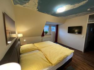 ein Schlafzimmer mit einem Bett mit gelber Decke in der Unterkunft FEWO Baltrum in Bad Zwischenahn