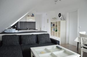 ein Wohnzimmer mit einem Sofa und einem Tisch in der Unterkunft Ferienwohnung Herzmuschel in Cuxhaven