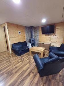 een woonkamer met 2 banken en een tv bij Alojamiento aeropuerto mocopulli 