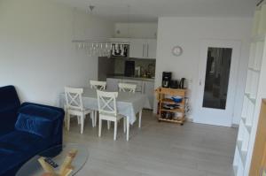 ein Wohnzimmer mit einem Tisch und Stühlen sowie eine Küche in der Unterkunft Ferienwohnung Meerzeit in Cuxhaven