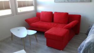 フェーマルンにあるFerienwohnung am Yachthafenのリビングルーム(赤いソファ、テーブル付)