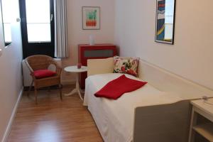 Zimmer mit einem Bett, einem Stuhl und einem Tisch in der Unterkunft Ferienwohnung Meeresrauschen in Fehmarn