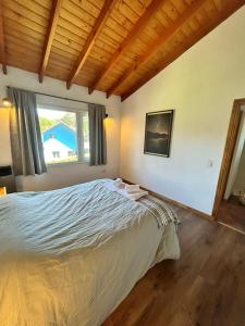 a bedroom with a bed and a large window at Sombra Verde in Villa La Angostura