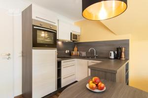 a kitchen with a bowl of fruit on a table at Traumhaftes Appartement mit Balkon - Odins Blick Wohnung 6 - mit Privatstrand, Sauna in Lobbe
