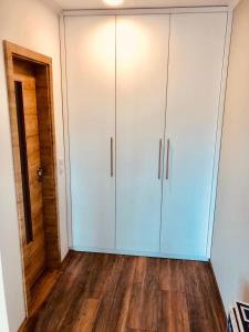 a room with white cabinets and wood floors at Traumhaftes Appartement mit Balkon - Odins Blick Wohnung 6 - mit Privatstrand, Sauna in Lobbe