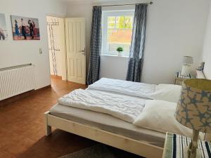 Schlafzimmer mit einem Bett, einem Fenster und einer Tür in der Unterkunft Neptun in Scharbeutz