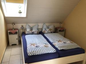 a bedroom with two beds and two tables and a window at Nixe in Scharbeutz