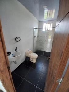 La salle de bains est pourvue de toilettes, d'un lavabo et d'une douche. dans l'établissement Casa en Condominio en Carmen de Apicala, à Carmen de Apicalá