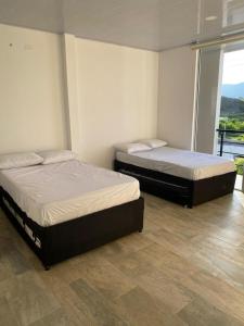 - 2 lits dans une chambre avec balcon dans l'établissement Casa en Condominio en Carmen de Apicala, à Carmen de Apicalá