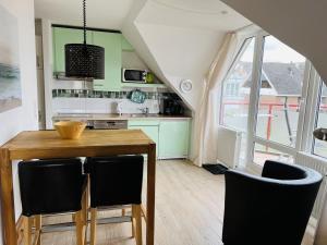 a kitchen with a wooden table and chairs at Witthus Nr. 16 in Scharbeutz